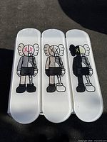 Three decks laid flat showing front-side KAWS Companion graphics