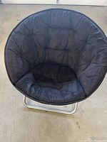 Front view of black padded saucer chair on metal folding base