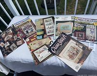 All seven cross-stitch publications laid out on table