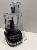 Front view showing base, bowl, lid, feed tube, pusher