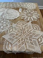 Assorted crocheted lace doilies and runners spread on table