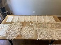 Overview of largest pieces on table including runner, oval doily, round doily, placemat