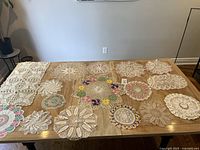 Full lot overview showing 16 crochet lace pieces on table