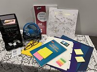 Overview of lot showing organizer, fan, glasses, paper, colouring book, folders, sticky notes