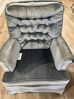 Front view showing tufted back, rolled arms, cushion