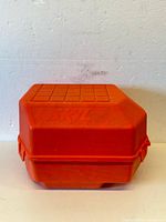 Closed orange SKIL branded hard plastic carrying case with embossed logo, square pattern on lid