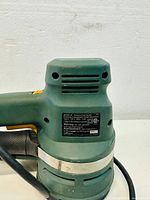 Close-up of the Black & Decker sander model and rating labels showing model number BDEQS300, certification marks.