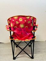 Back view of foldable beach chair showing sun pattern fabric and black metal frame.