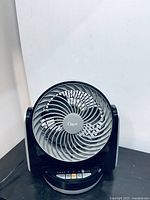 Black Ozeri desk fan showing its full front view and circular grill with blades.