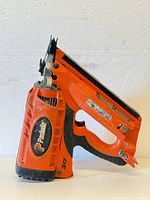 Side view of Paslode cordless framing nailer showing brand logo, thumb trigger, and magazine.