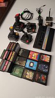 Photo showing Atari 2600 console, controllers, and game cartridges spread on table