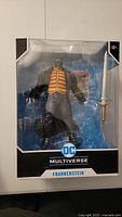 Front view of McFarlane DC Multiverse Frankenstein action figure in window box showing figure and sword