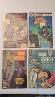 Four vintage Gold Key comic books laid out, each bagged and boarded in protective sleeves. Titles visible include Brothers of the Spear, Ghost Manor, and two Boris Karloff Tales of Mystery comics.