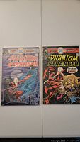 Front view of two comic books The Phantom Stranger issues #41 and #42 laid side by side.