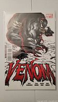 Full view of Venom #1 comic book cover with Venom crouching and title text visible.