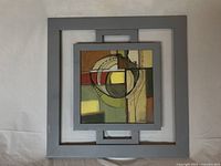 Frontal view of abstract print in square gray frame showing artwork and frame condition.