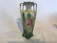 Front view of Art Nouveau vase showing pink floral design and ornate handles