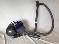 Full view of grey and purple Dyson DC37 canister vacuum assembled with hose, wand and floor head