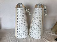 Pair of Ehlen Johansson Torna lights with laminated birch frames and white perforated metal covers, shown side by side with cords coiled.