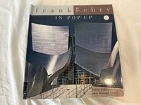 Front cover of hardcover pop-up book titled 'Frank Gehry In Pop-Up' showing modern architectural design.