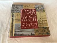 Closed hardcover book showing the dust jacket with title and architectural images