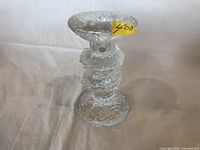 Glass Festivo candlestick with textured surface, photo from an angle showing the candle holder top and stem detail.