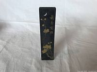 Front view of the Japanese ink block showing gold floral design and moon symbol.
