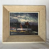 Frontal image of framed oil painting depicting houses and bare trees beneath a moody sky.