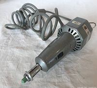 Full view of the grey hammertone vintage electric eraser with coiled cord, showing the eraser tip at the end.