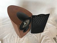 Photo of the KEF iQ3 speaker with grille removed showing the coaxial driver and wood finish cabinet.