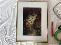 Framed original signed art photo of milkweed plant, displayed with glasses, pen, and tape for scale.