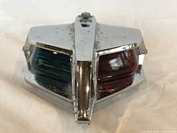 Front view of vintage nautical bow deck light showing red and green thick glass lenses and chrome housing.
