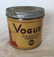 Front view of the vintage Vogue cigarette tobacco tin showing brand and label design with mild cigarette tobacco text and woman's head profile graphic.