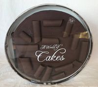 Top view of the 'World of Cakes' book showcasing the chocolate cake design and curls with title print on clear plastic covering
