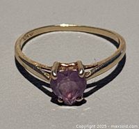 Front view of ring showing oval faceted purple amethyst set in prong 10K yellow gold band