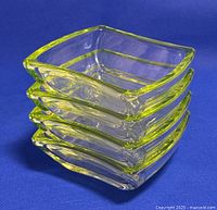 Stacked view of the four square glass bowls showing yellow-green tinted edges and clear glass bodies.