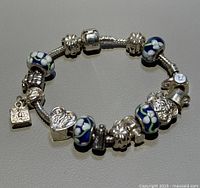 Full view of bracelet laid flat, showing all beads and charms