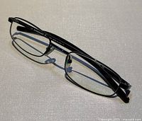 Top angled view of black rectangular metal eyeglass frames showing overall design and condition.