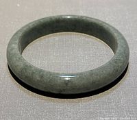 Front view of the natural jade D-shaped bangle showing smooth polished surface and stone grain.