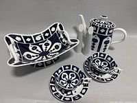 Entire tea set and serving dish arranged together showing blue and white geometric and floral patterns and rectangular serving dish with built handles