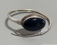 Front and angled view of the silver open cuff bracelet with black onyx stone showing design and condition.