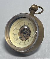 Front-side angled photo showing the vintage glass ball clock with visible inner gears and Roman numeral dial.