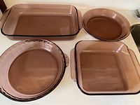 All four Amethyst Pyrex dishes displayed together on a white surface showing the large rectangular, square, round quiche, and scalloped pie dishes.