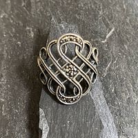 Top view photo showing the ring's intricate open swirl design with marcasite stone cluster in the center.