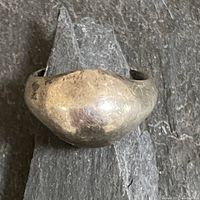 Close-up front view of the smooth rounded sterling silver ring showing slightly tarnished and worn patina