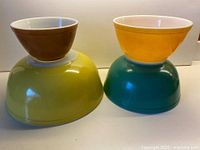 Photo of all four nesting bowls stacked together showing lemon yellow, forest green, tangerine, and milk chocolate colors.