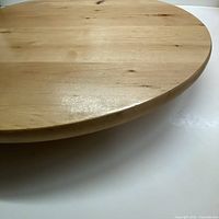 Close up view of the wooden Lazy Susan showing smooth circular surface and light wood grain finish.