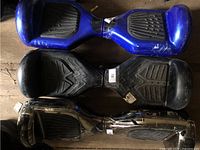 Top view of stacked blue, black and chrome hoverboards showing overall condition and finishes