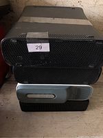 Stack of four Xbox 360 consoles showing front grills and color difference