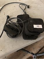 Stack of five Apple TV boxes with two power cords visible